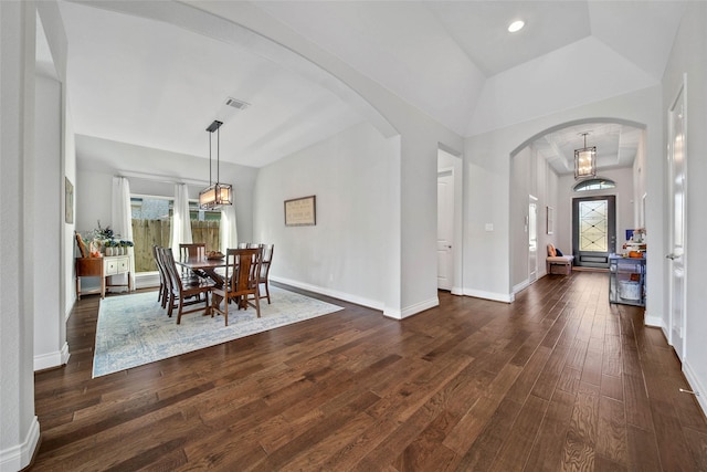 dining space featuring a raised ceiling, dark hardwood / wood-style flooring, and plenty of natural light