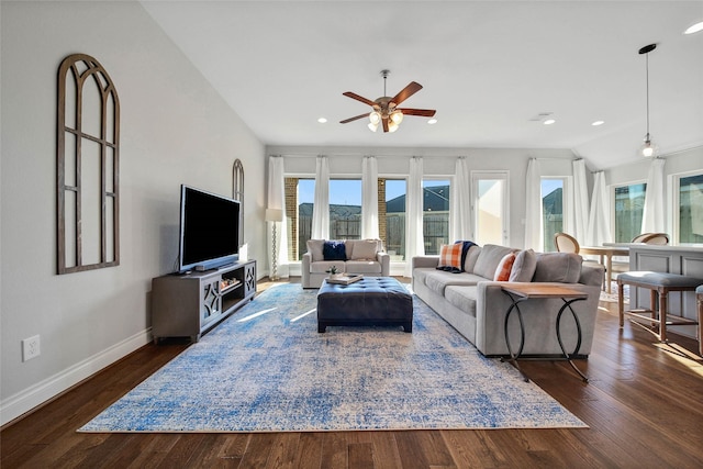 living room featuring ceiling fan, dark hardwood / wood-style floors, a wealth of natural light, and vaulted ceiling