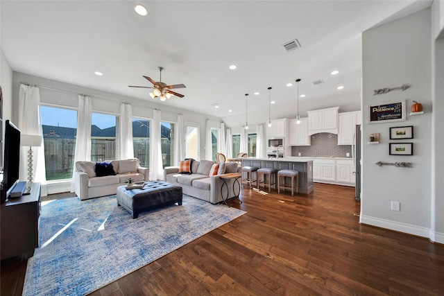 living room with ceiling fan and dark wood-type flooring