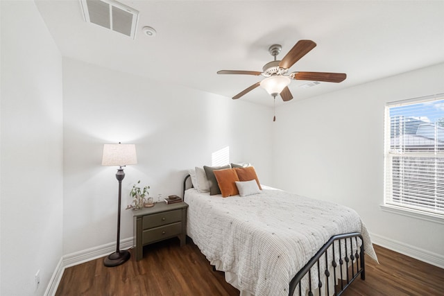 bedroom with dark hardwood / wood-style flooring and ceiling fan