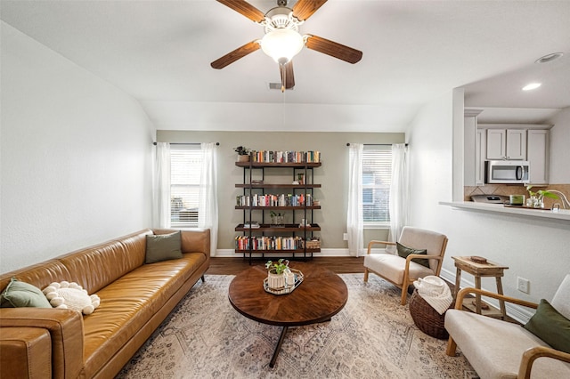 living room featuring hardwood / wood-style flooring, ceiling fan, and lofted ceiling