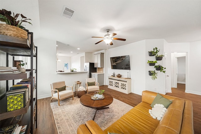 living room with ceiling fan and dark hardwood / wood-style flooring