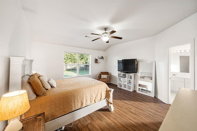 bedroom with ceiling fan, lofted ceiling, dark wood-type flooring, and connected bathroom