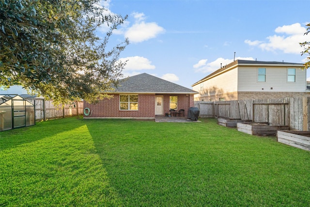 back of property featuring a yard and an outbuilding