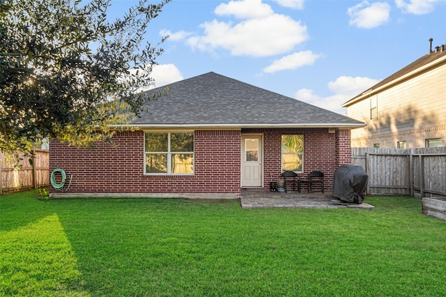 rear view of house with a yard and a patio