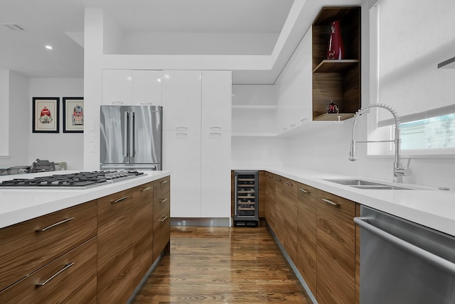 kitchen featuring sink, dark wood-type flooring, white cabinetry, stainless steel appliances, and wine cooler