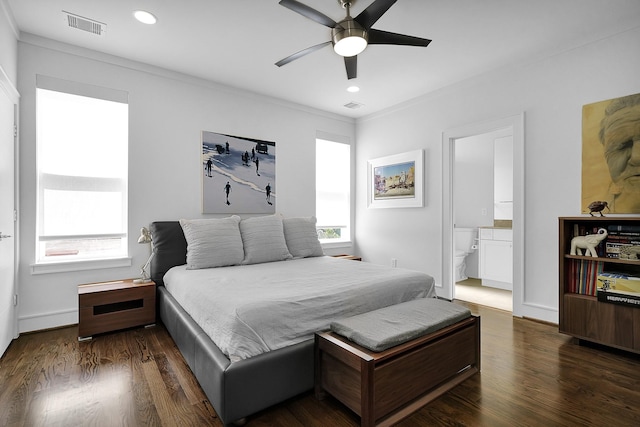 bedroom featuring connected bathroom, dark wood-type flooring, ornamental molding, and ceiling fan