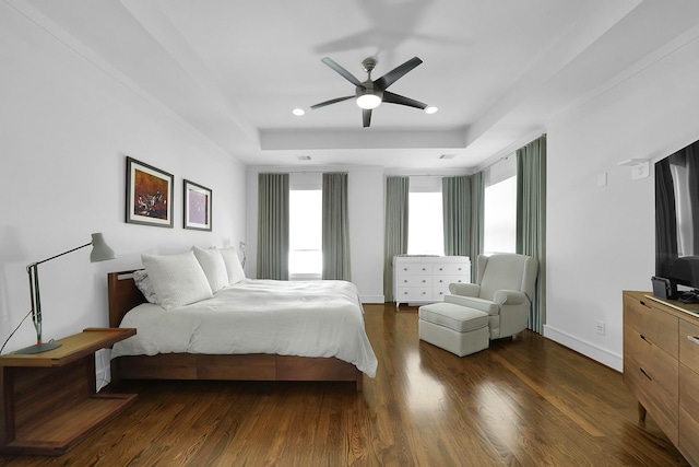 bedroom with a raised ceiling, dark hardwood / wood-style floors, and ceiling fan