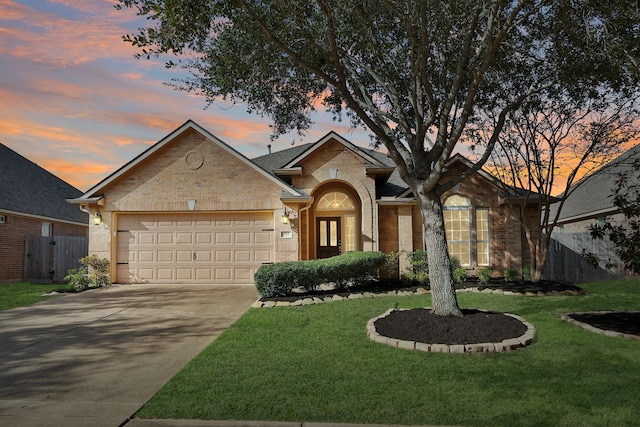 ranch-style home with a garage and a yard