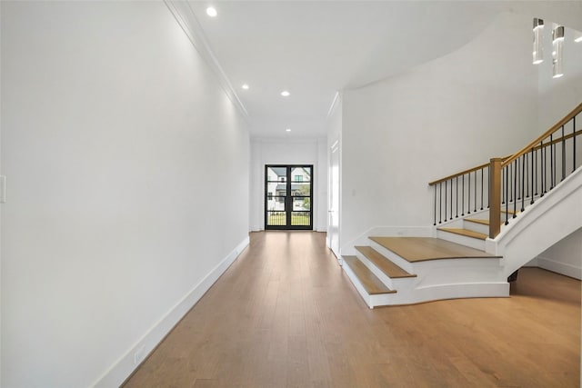 foyer entrance featuring crown molding and hardwood / wood-style flooring