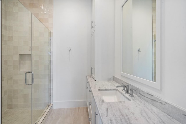 bathroom featuring vanity and a shower with shower door