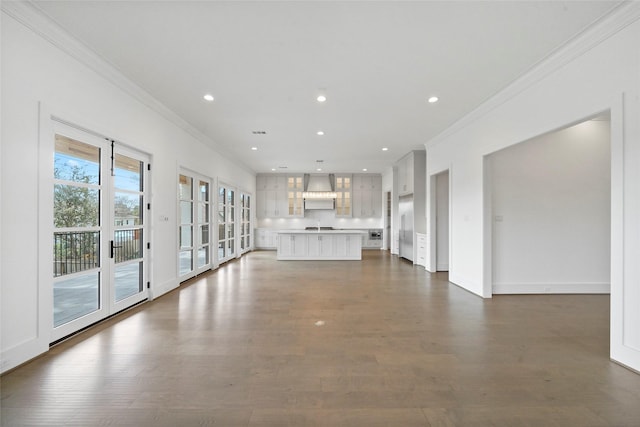 unfurnished living room featuring dark hardwood / wood-style floors and crown molding