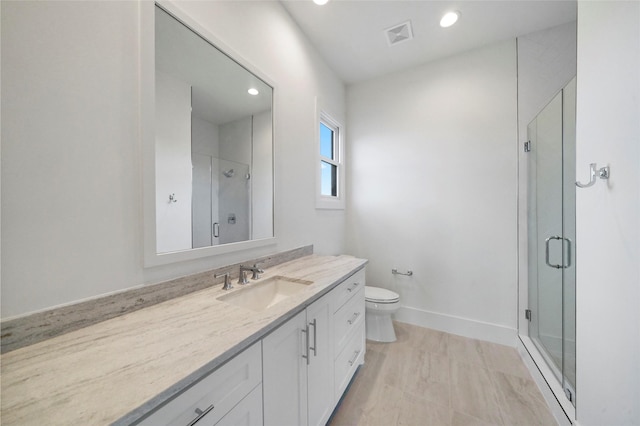 bathroom with vanity, toilet, and an enclosed shower