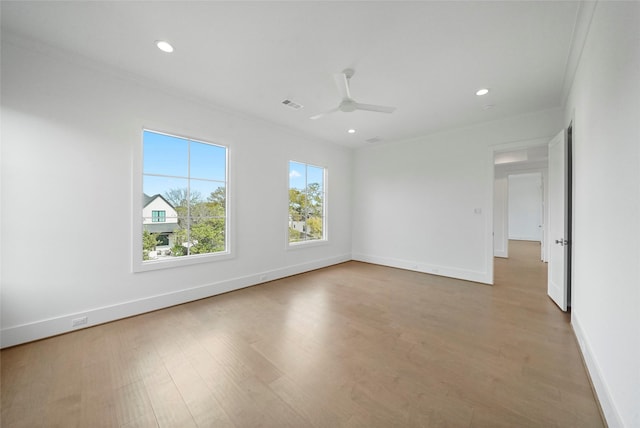 empty room with crown molding, ceiling fan, and light hardwood / wood-style floors