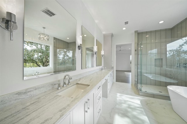 bathroom featuring vanity, ceiling fan with notable chandelier, and independent shower and bath