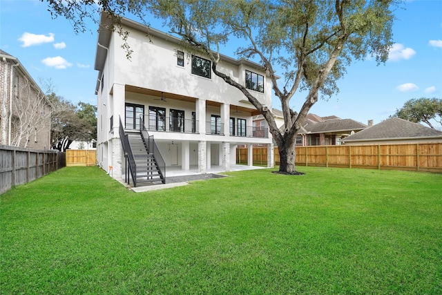 back of property with a balcony, a yard, and a patio