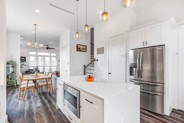 kitchen featuring light stone countertops, stainless steel appliances, ceiling fan, white cabinets, and a kitchen island