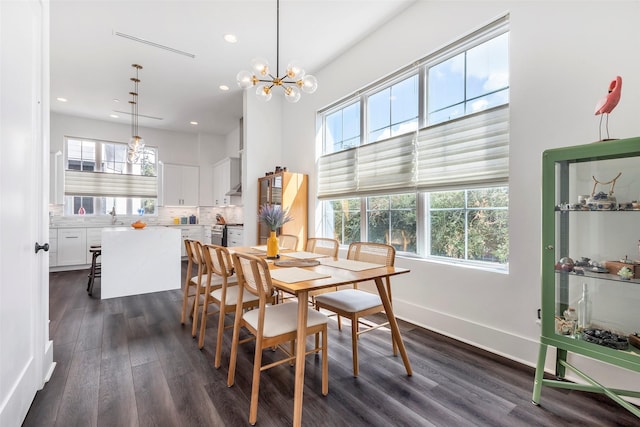 dining room with dark hardwood / wood-style flooring, sink, and an inviting chandelier