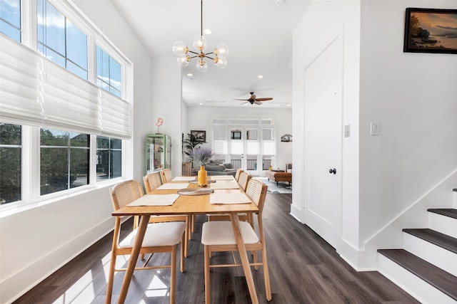 dining space with ceiling fan with notable chandelier and dark hardwood / wood-style floors