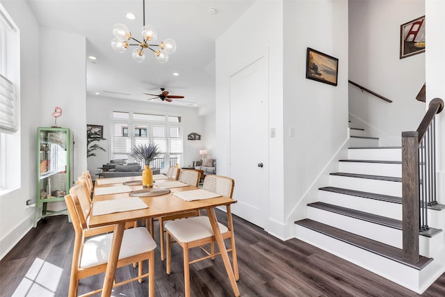 dining room with dark hardwood / wood-style flooring and ceiling fan with notable chandelier