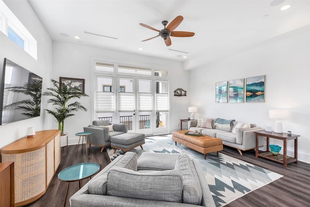 living room with a wealth of natural light, dark wood-type flooring, and ceiling fan