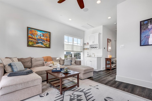 living room featuring ceiling fan and dark wood-type flooring