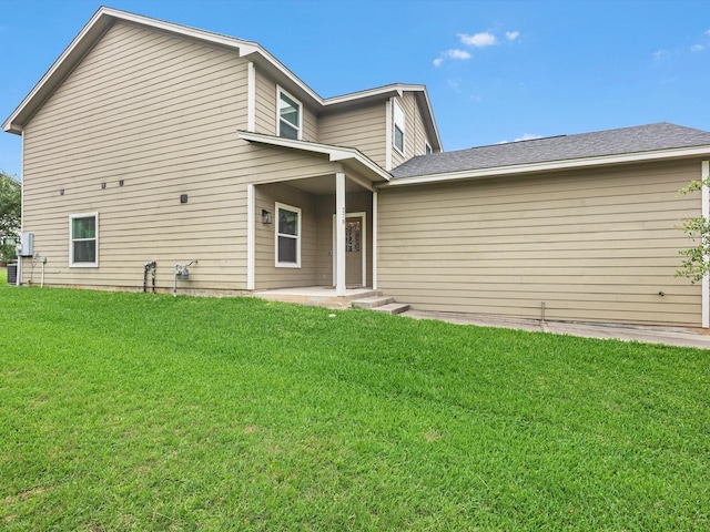 rear view of house featuring a lawn