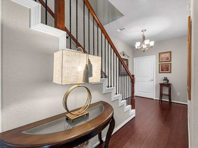 entrance foyer featuring dark hardwood / wood-style flooring and an inviting chandelier