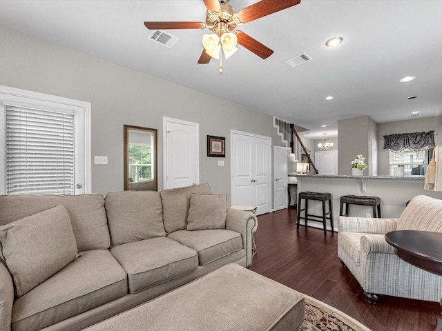 living room featuring plenty of natural light, ceiling fan, and dark hardwood / wood-style flooring