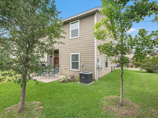 rear view of property featuring central AC unit, a patio area, and a lawn