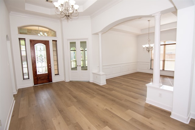 foyer featuring light hardwood / wood-style floors, a tray ceiling, and an inviting chandelier