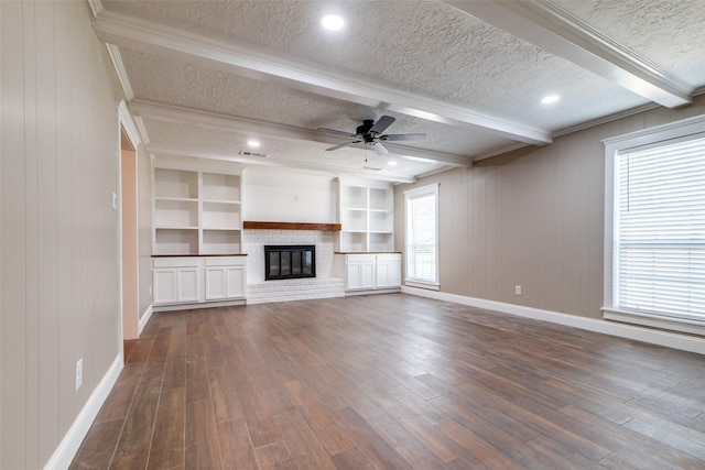 unfurnished living room featuring beam ceiling, dark hardwood / wood-style flooring, built in features, and a textured ceiling