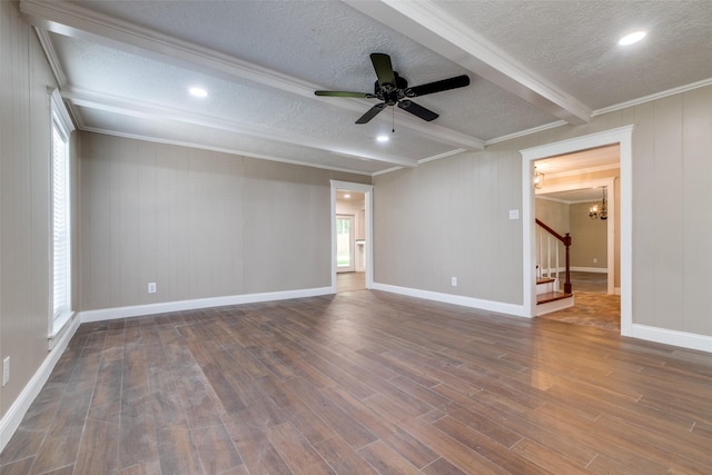 empty room with dark hardwood / wood-style flooring, ornamental molding, ceiling fan with notable chandelier, a textured ceiling, and beam ceiling