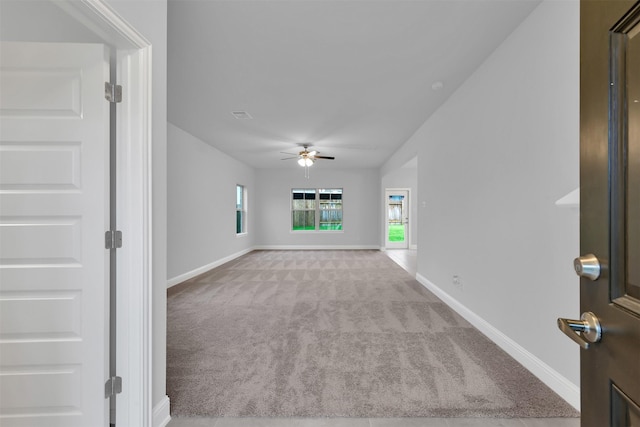 unfurnished living room with light colored carpet and ceiling fan