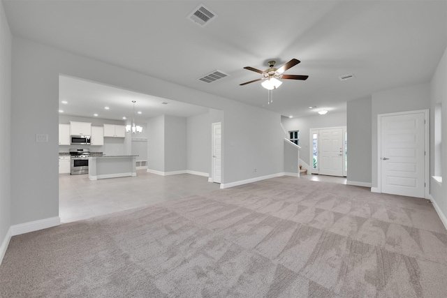 449 Terra Vista Cir, Montgomery, TX 77356 - unfurnished living room with light carpet, recessed lighting, a ceiling fan, a chandelier, and stairs