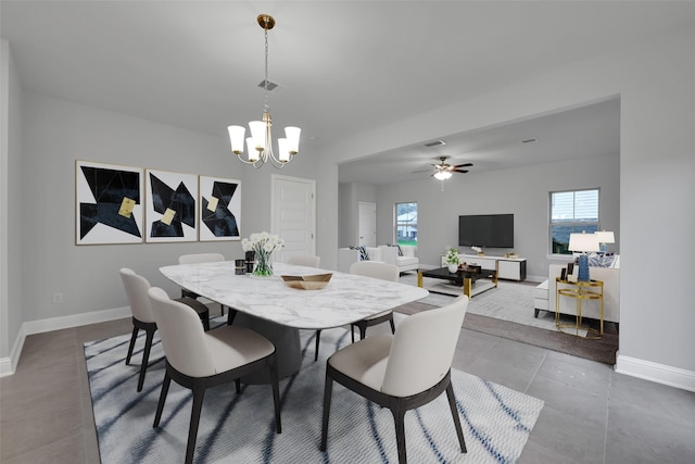 dining area with a wealth of natural light, tile patterned flooring, and ceiling fan with notable chandelier