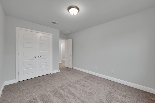 unfurnished bedroom with light carpet and a closet