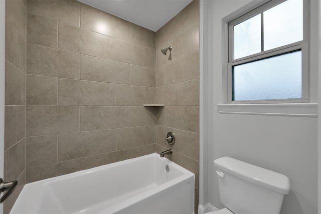 bathroom with tiled shower / bath combo, toilet, and a wealth of natural light