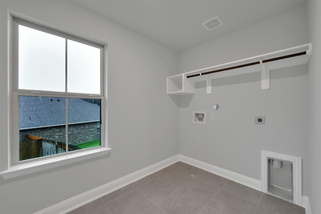 clothes washing area featuring hookup for an electric dryer, gas dryer hookup, tile patterned floors, and washer hookup