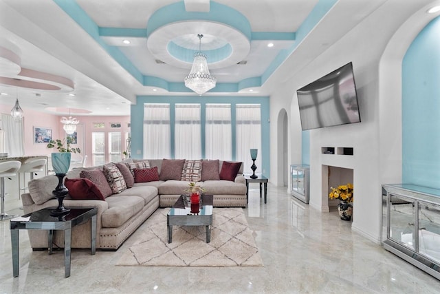 living room with a chandelier and a raised ceiling