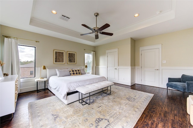 bedroom featuring crown molding, ceiling fan, a raised ceiling, dark hardwood / wood-style floors, and a closet