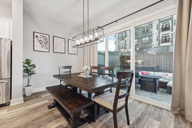 dining space with a notable chandelier and light hardwood / wood-style floors