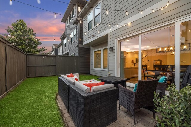 patio terrace at dusk featuring a lawn and an outdoor living space