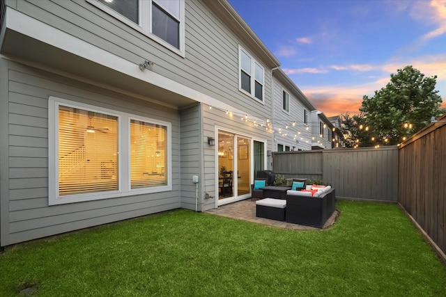 back house at dusk featuring an outdoor hangout area and a yard