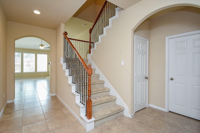 stairs featuring tile patterned floors and ceiling fan