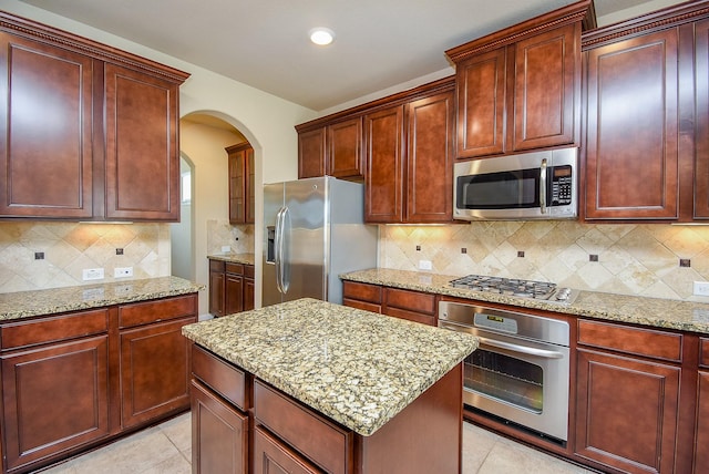 kitchen with light stone countertops, light tile patterned floors, and stainless steel appliances