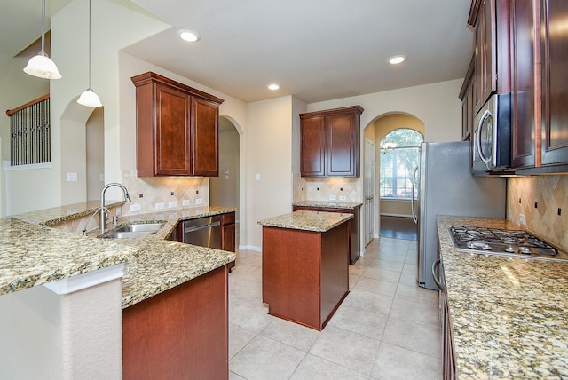 kitchen featuring light stone countertops, stainless steel appliances, sink, and tasteful backsplash