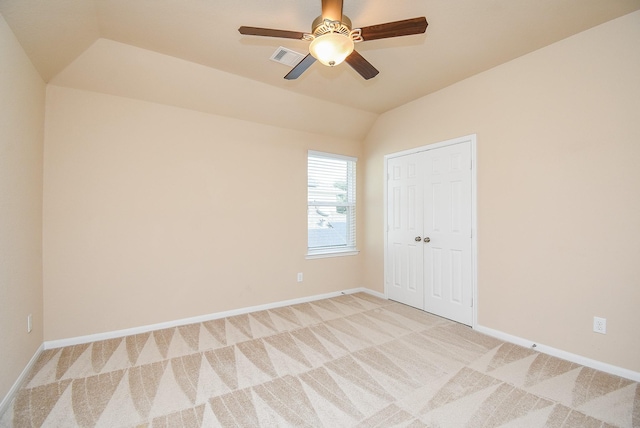 carpeted spare room with ceiling fan and lofted ceiling