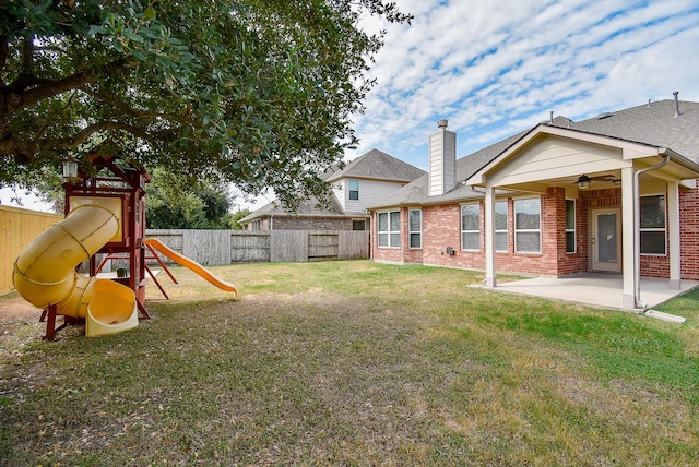 view of yard with ceiling fan, a playground, and a patio