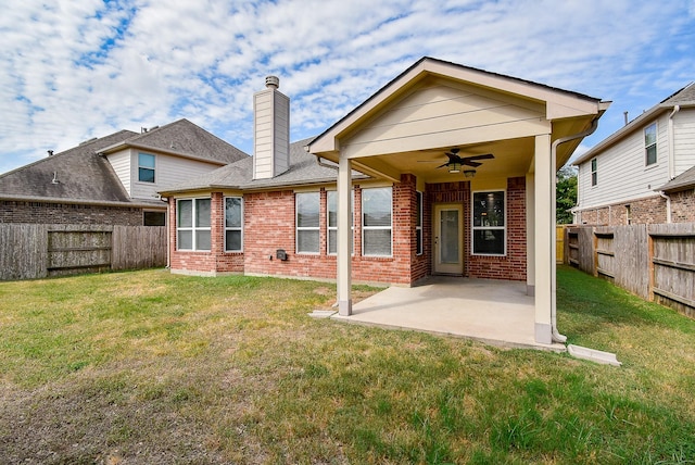 back of house featuring a lawn, ceiling fan, and a patio